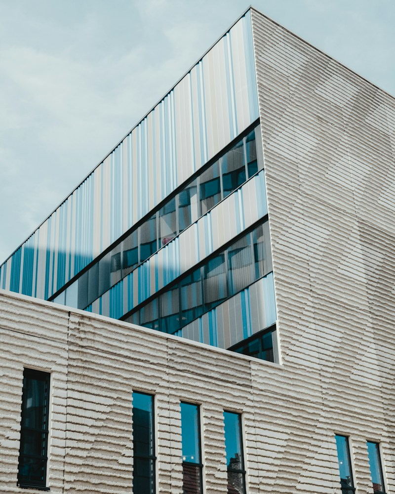 Angular concrete and glass building against a cloudy sky